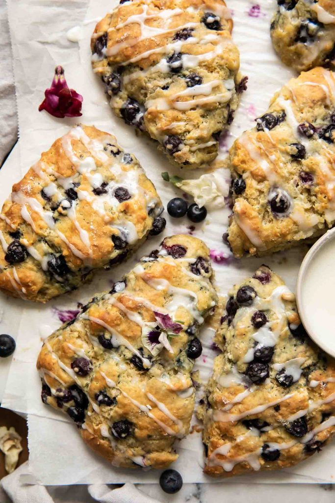 Top shot of Maple Blueberry Scones on a baking sheet with parchment paper.