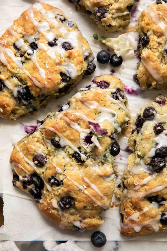 Close up of Maple Blueberry Scones on a baking sheet with parchment paper.