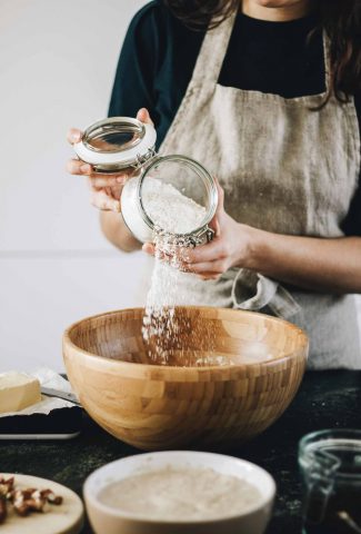 Woman pouring almond flour into a mixing bowl.