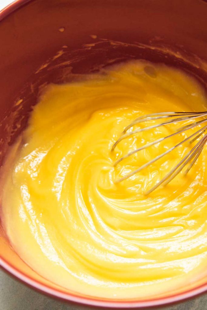 Banana vanilla pudding being whisked together in a mixing bowl.