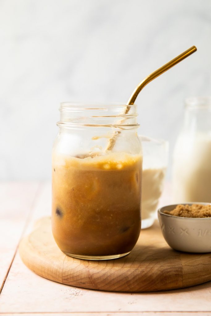 Iced Brown Sugar Oatmilk Shaken Espresso in a mason jar with a metal straw.