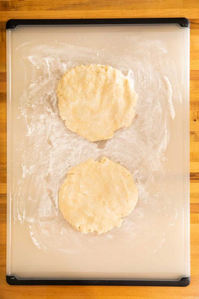 Two disks of pastry dough on a cutting board.