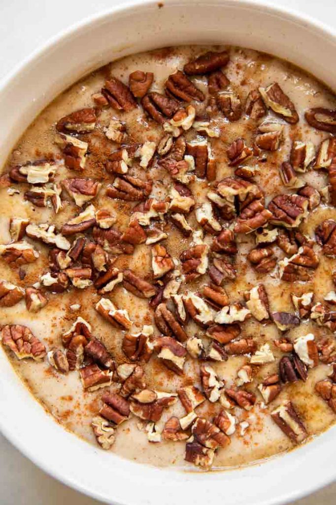 Maple whiskey pudding cake with pecans and cinnamon in a baking dish.