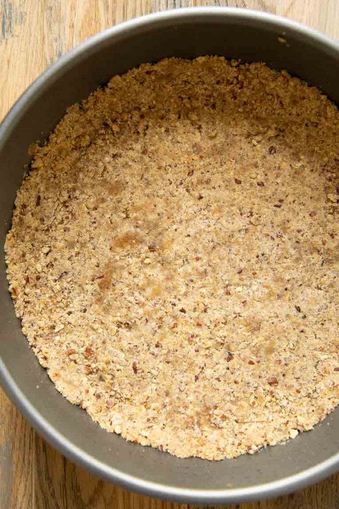 Pecan graham cracker crust pressed into a springform pan.