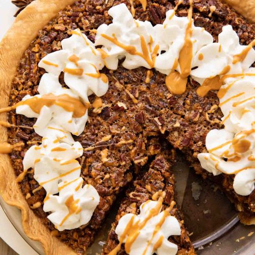 Top shot of the best Butterscotch Pecan Pie recipe with whipped cream and butterscotch drizzle.