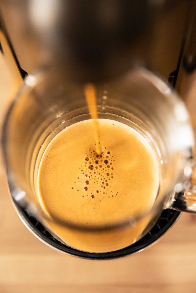 Nespresso machine brewing espresso into a coffee mug.