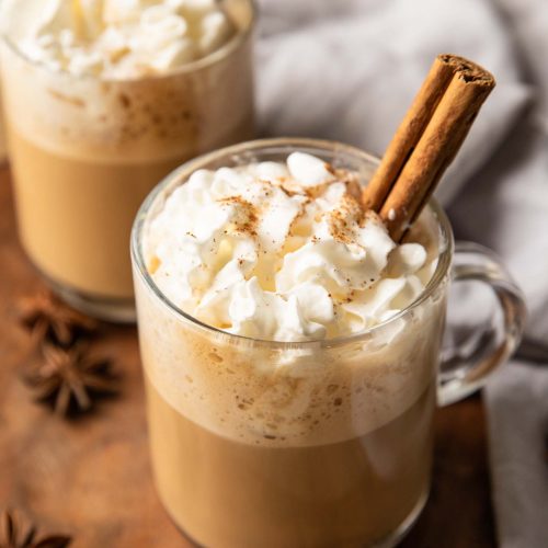Homemade eggnog latte recipe in two mugs with whipped cream.
