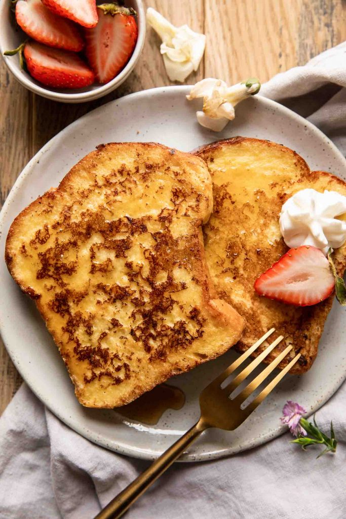 Top shot of Buttermilk French Toast on a plate with whipped cream.