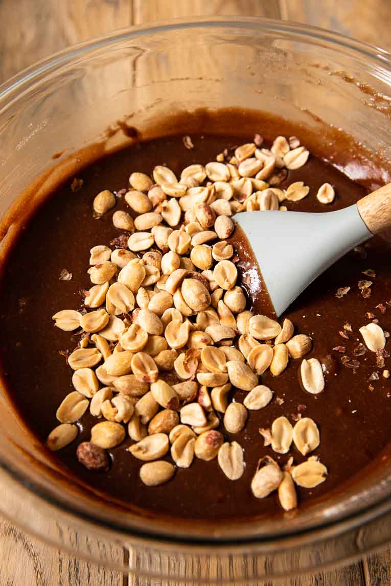 Brownie batter in a bowl with peanuts.