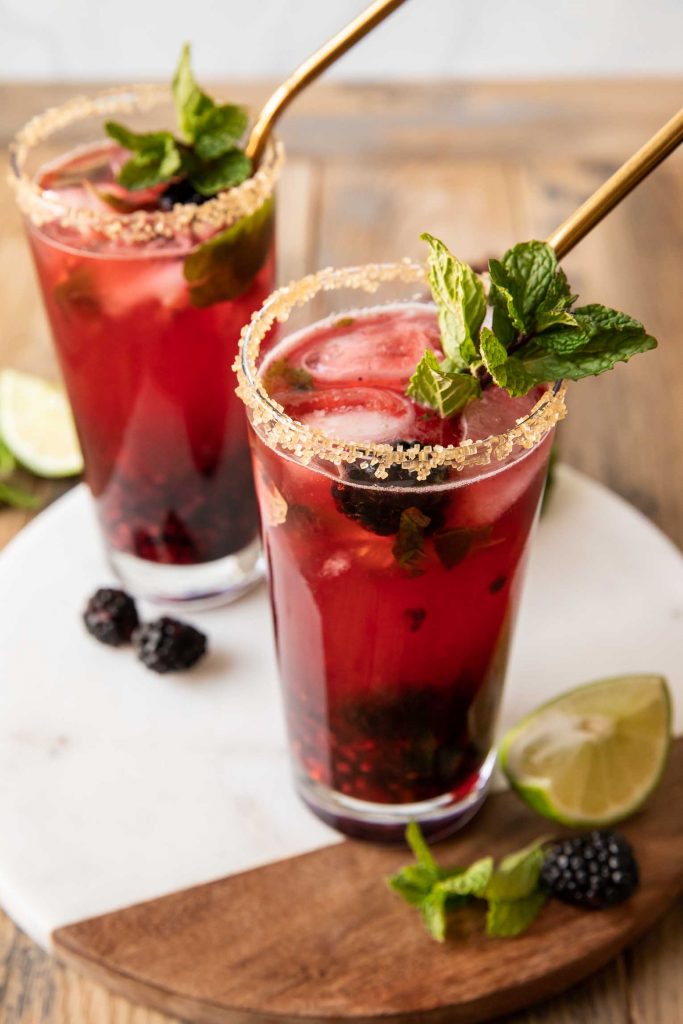 Angled photo of Blackberry Mojitos with lime and mint.