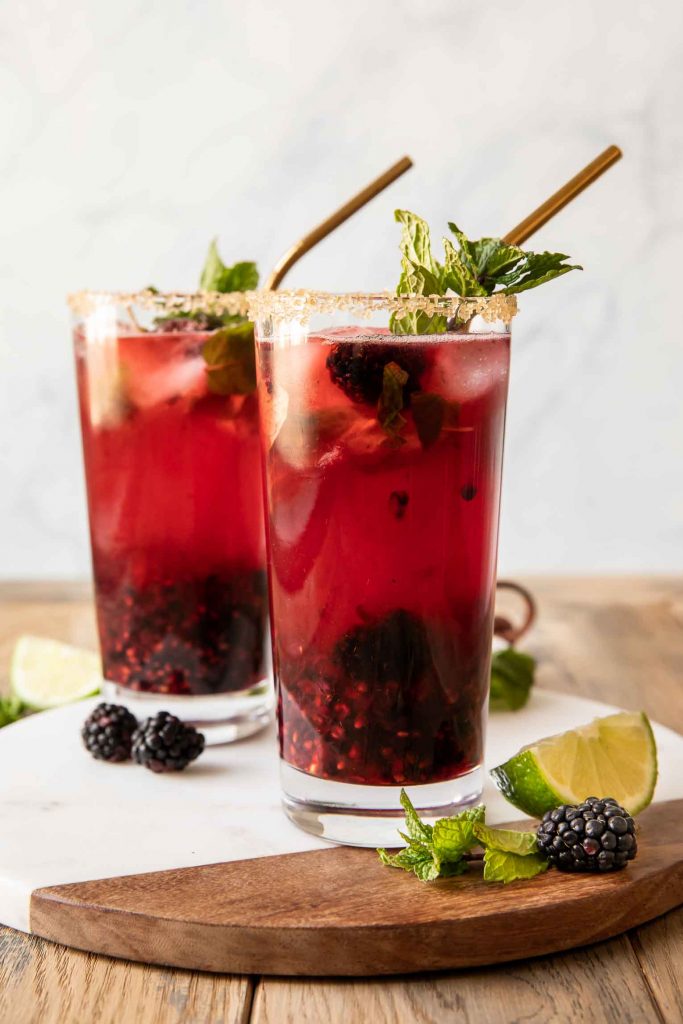 Blackberry mint mojito recipe in a glass with a straw.
