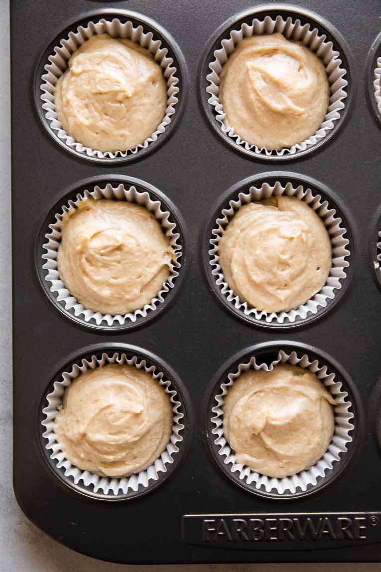Vanilla cupcake batter poured into cupcake liners.