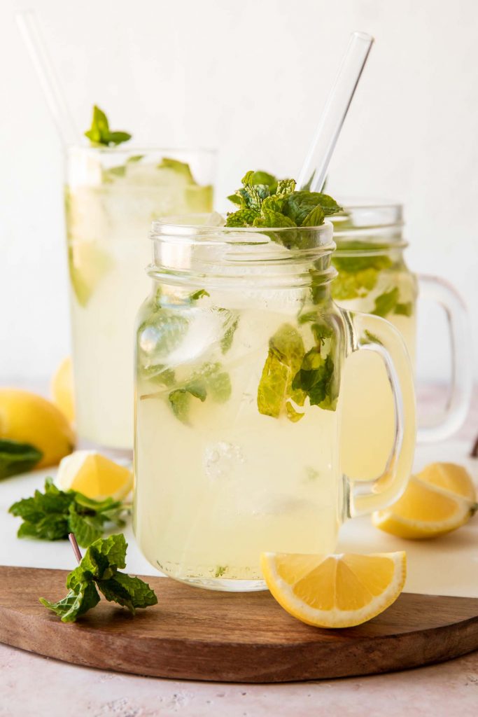Mint lemonade recipe in a glass with a straw and fresh mint.
