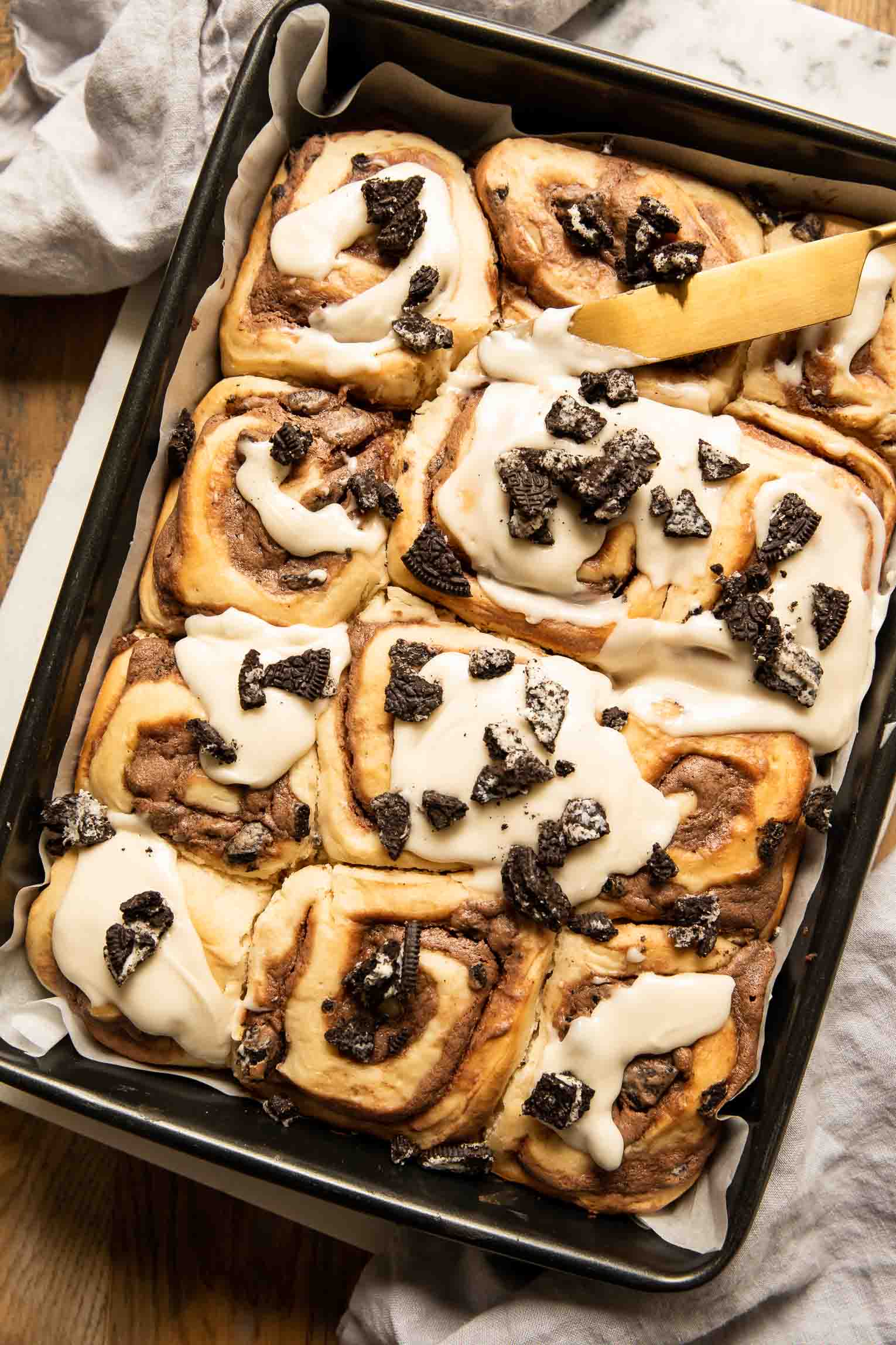 Cookies & Cream Cinnamon Rolls in a pan with icing.