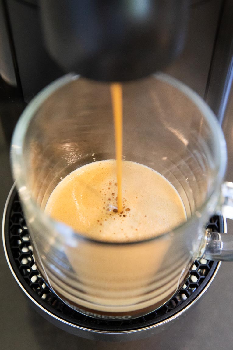 Espresso being brewed into coffee mug.