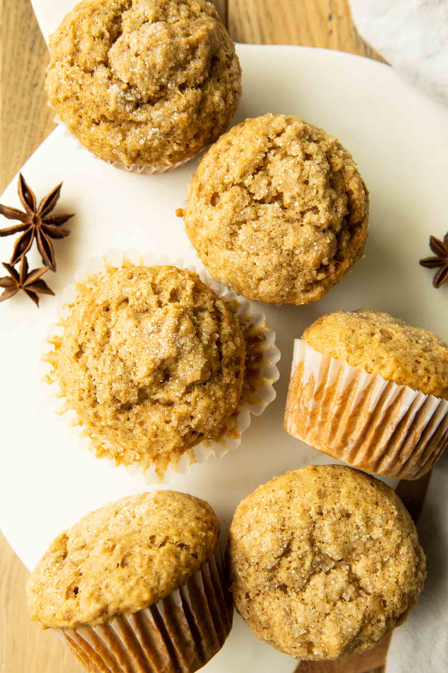 Top photo of apple cider muffins on a serving board with star anise.