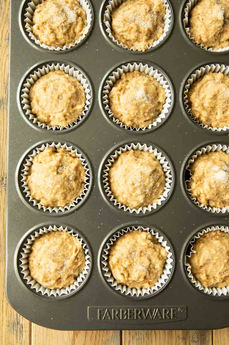 Apple cider muffins batter poured into muffin tin.