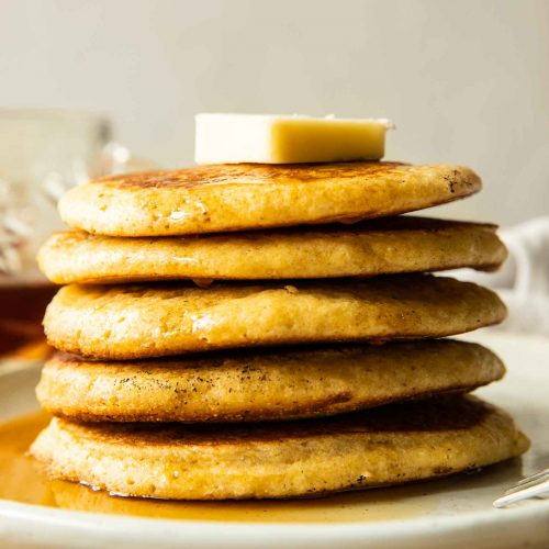 Cornbread pancakes recipe with butter on a plate.