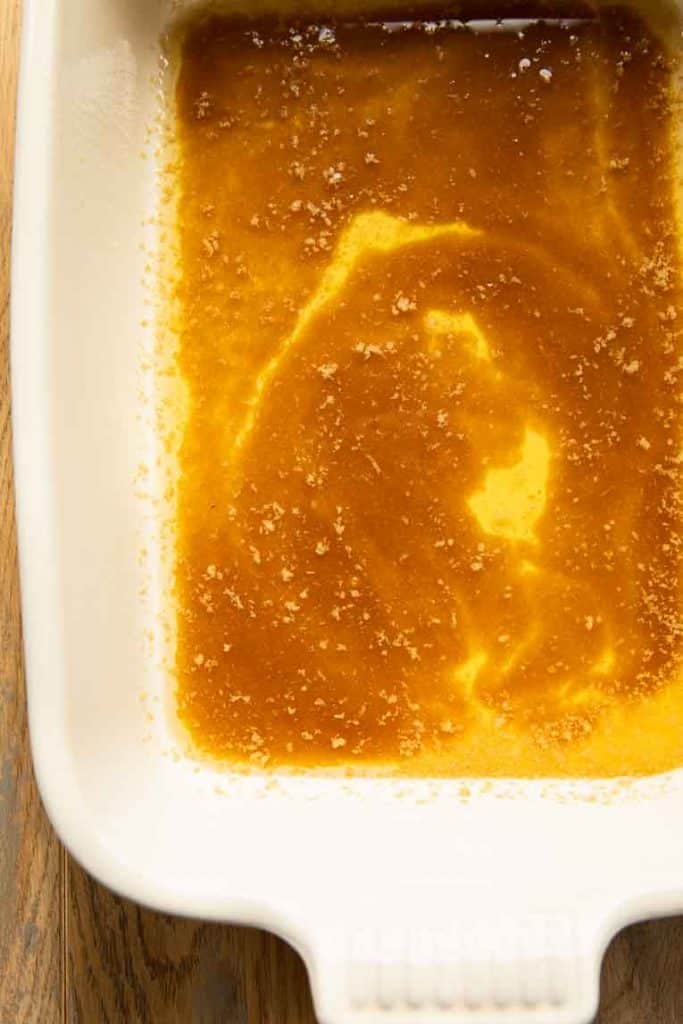 Melted butter and brown sugar in casserole dish.