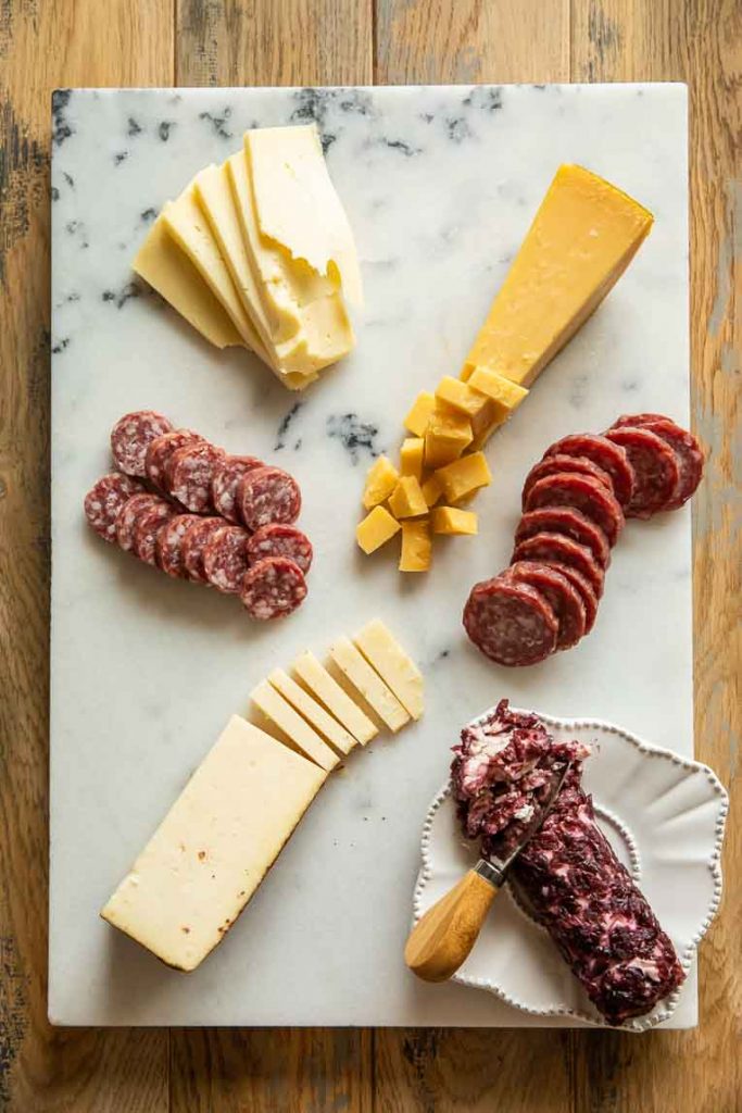 Cheese and meat on a charcuterie board.