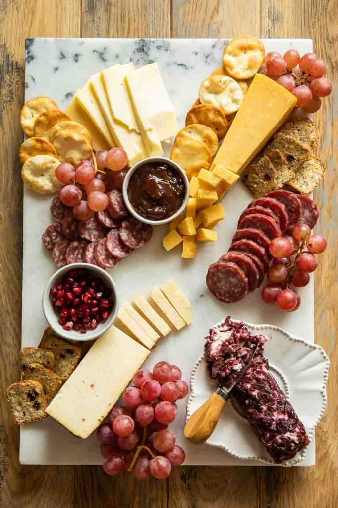 Adding crackers to a Christmas Charcuterie Board.