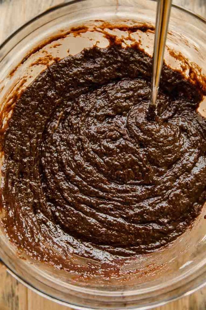 Brownie batter being mixed in a bowl.