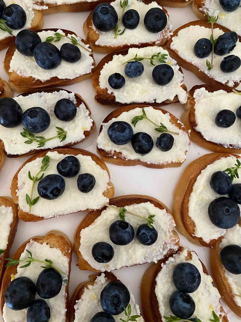 Pieces of toast with ricotta cheese and berries.
