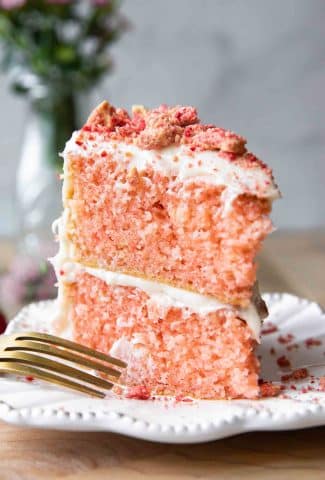 Close up of strawberry cake with buttercream icing and strawberry crunch on top.