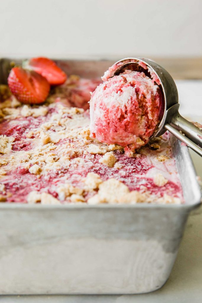 Across photo of Strawberry Swirl Cheesecake Ice Cream scooped out of the pan.