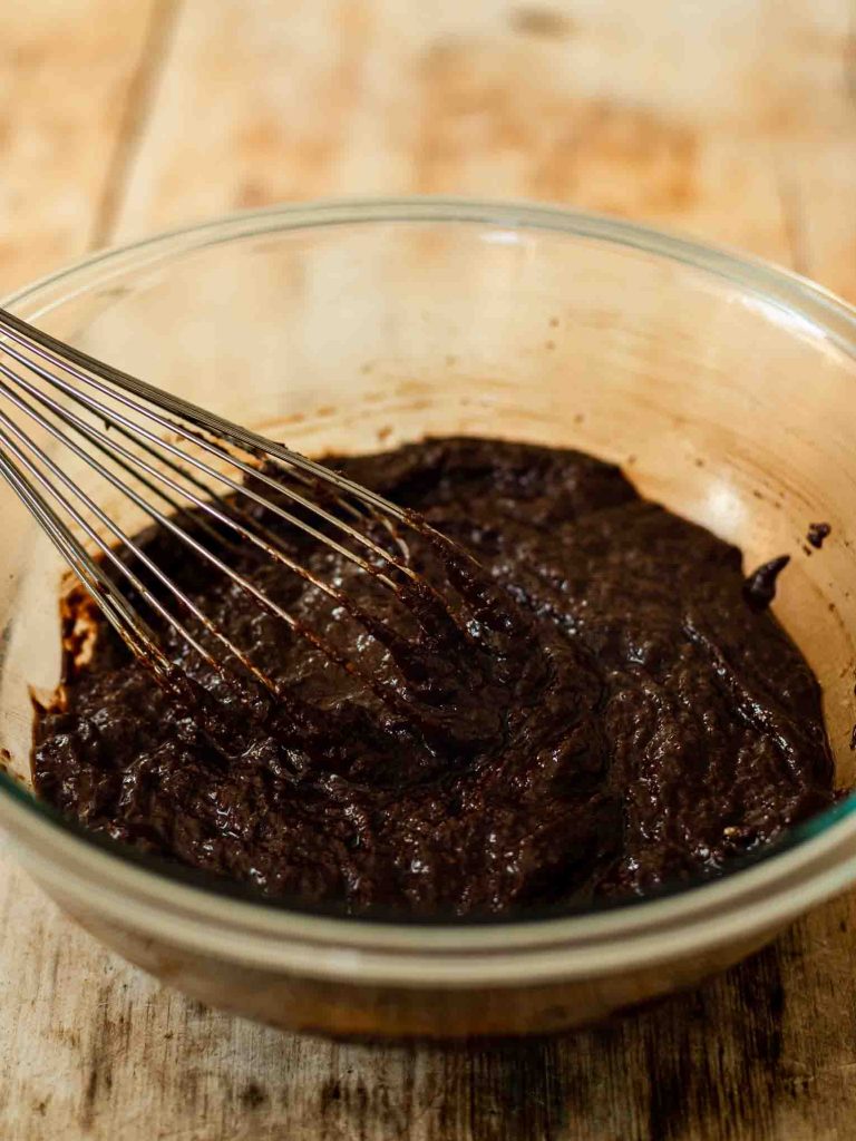 Brownie batter being whisked in a bowl.
