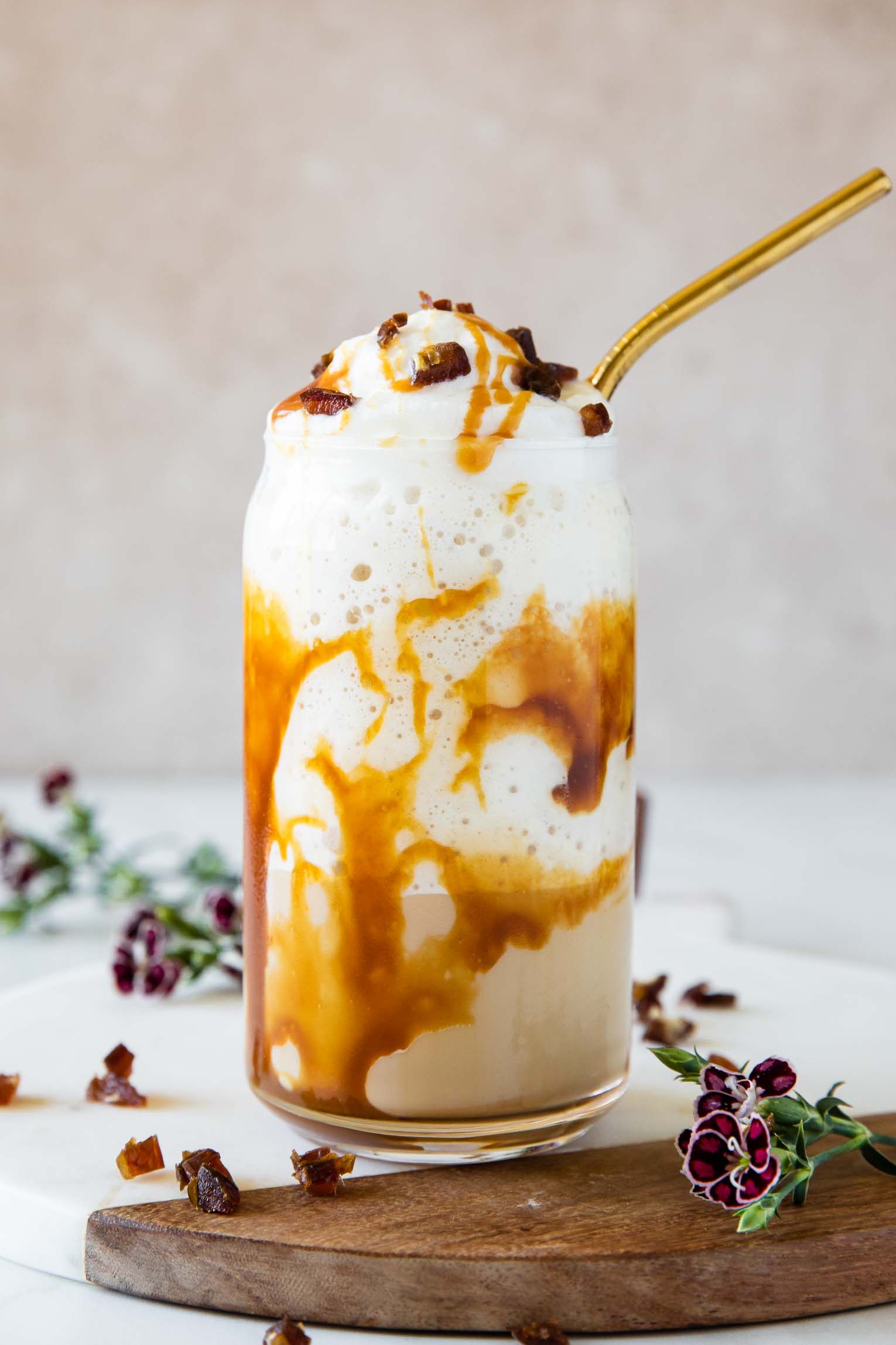 Caramel Ribbon Crunch Frappuccino recipe in a glass with gold straw.
