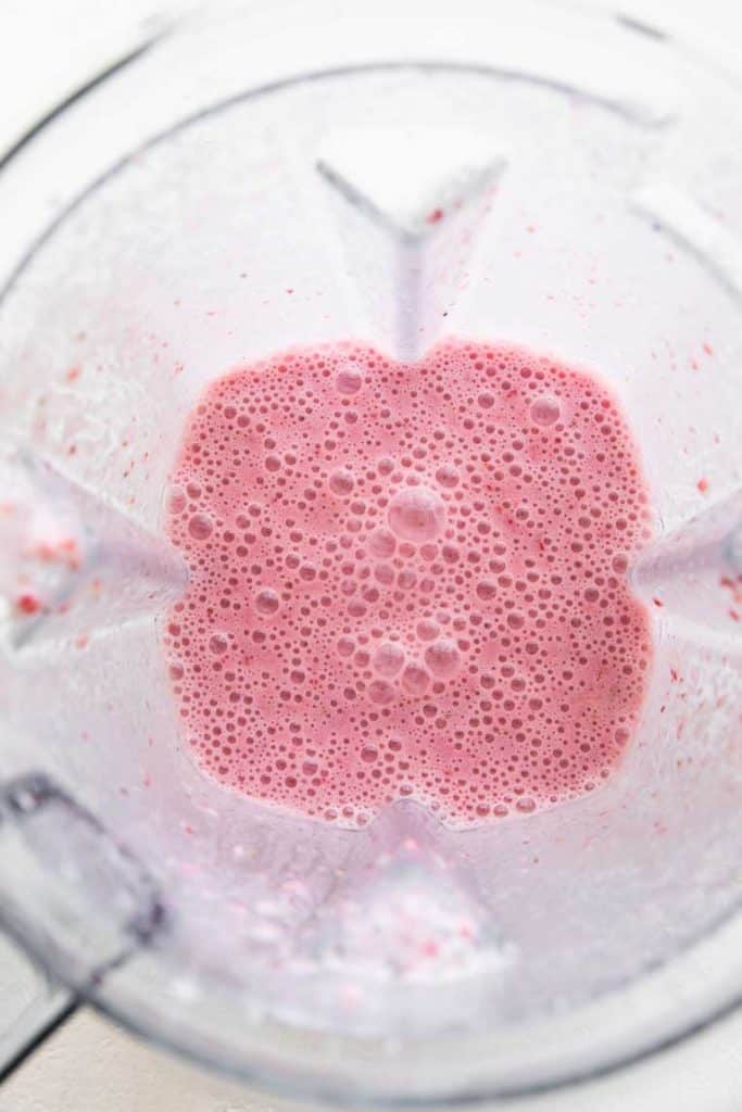 Strawberry milk being blended.