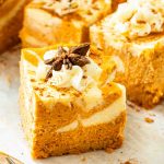 Close up of Pumpkin Swirl Cheesecake Bars recipe with whipped cream.