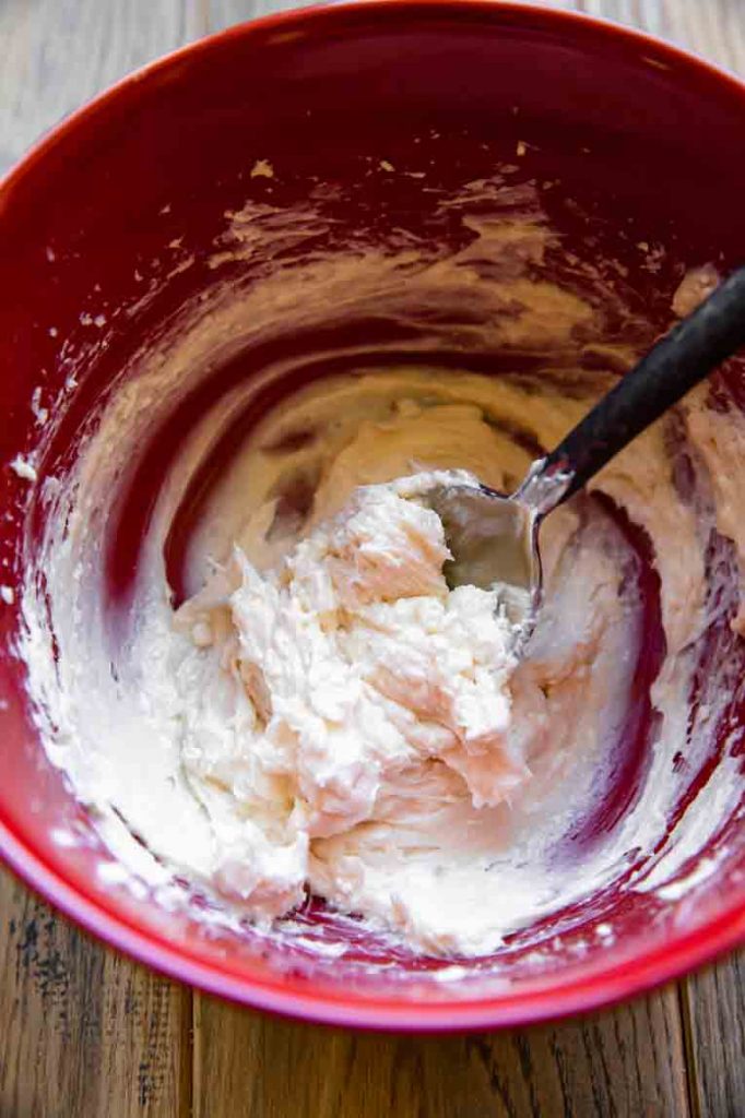 Cheesecake filling being mixed in a bowl.