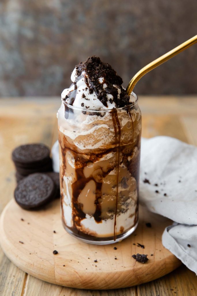 Angled photo of Mocha Cookie Crumble Frappuccino with whipped cream, chocolate sauce, and Oreo cookies.
