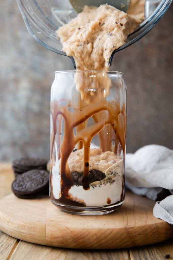 Mocha Cookie Crumble Frappuccino being poured into glass from blender.