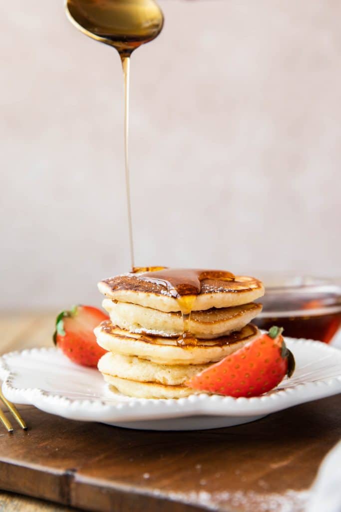 Syrup pouring over stack of Mini Pancakes.