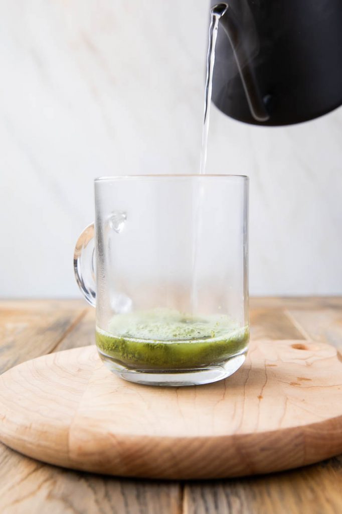 Hot water being poured into matcha cup.