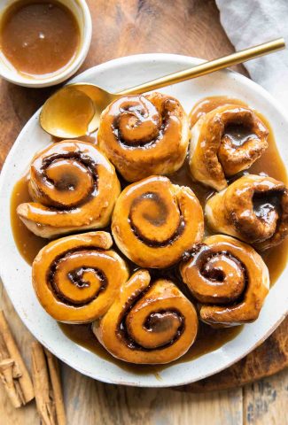 Air Fryer Cinnamon Rolls on a plate with a spoon.