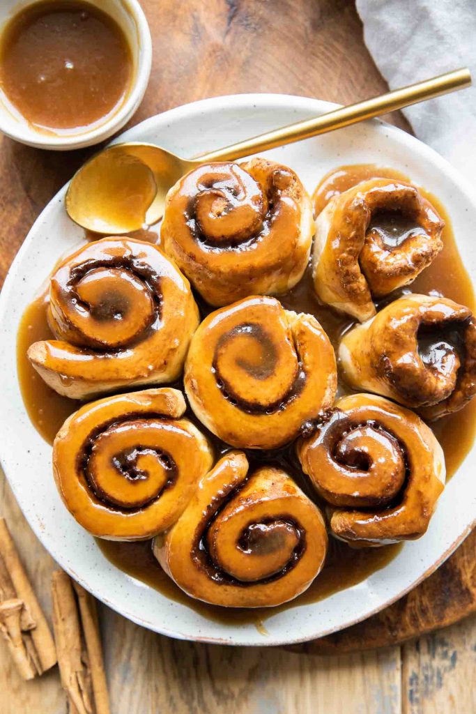 Air Fryer Cinnamon Rolls on a plate with a spoon.