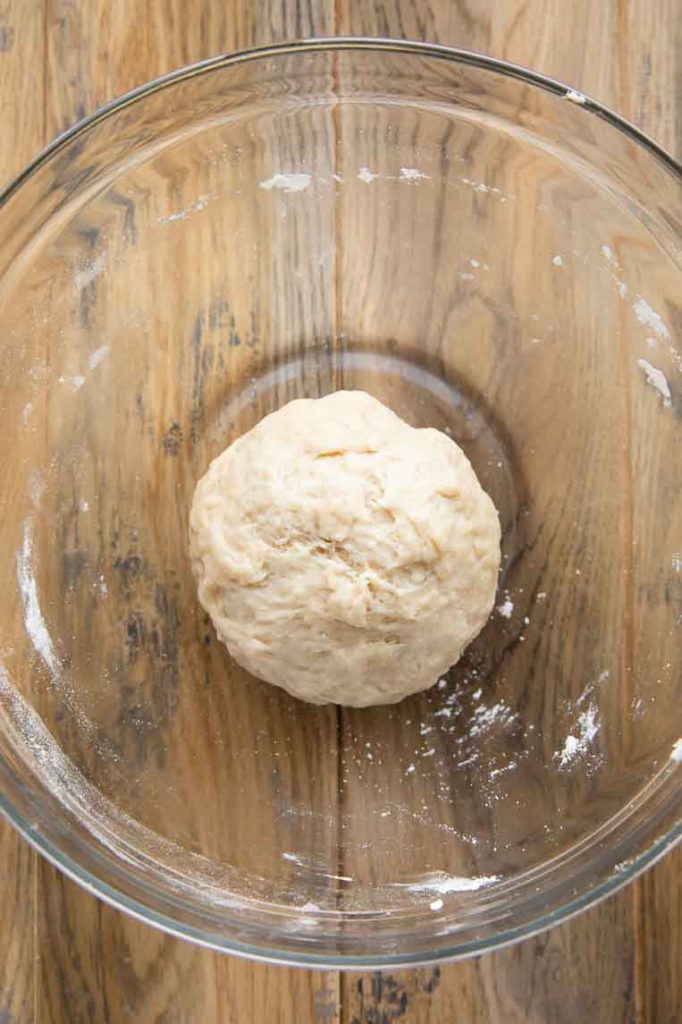Ball of cinnamon roll dough in a mixing bowl.