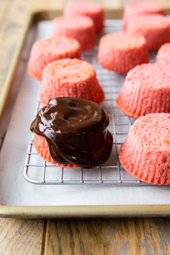 Chocolate ganache setting over strawberry cupcake.