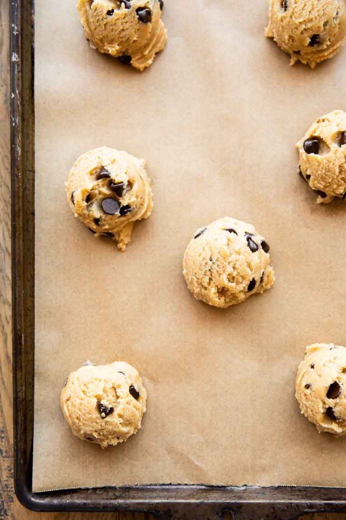 Chocolate chip cookie dough on a baking sheet.