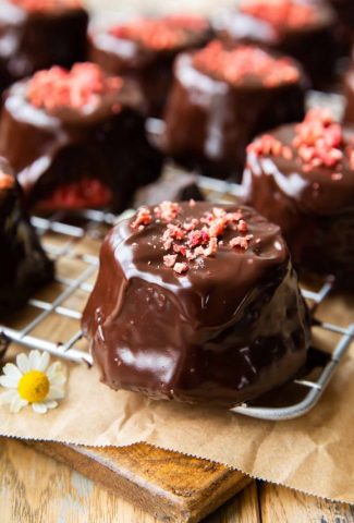 Angled photo of strawberry cupcakes with chocolate ganache.