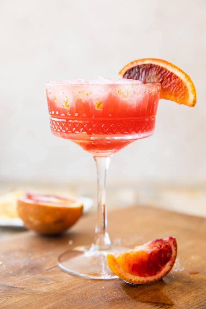 Blood orange margarita in a coupe glass.
