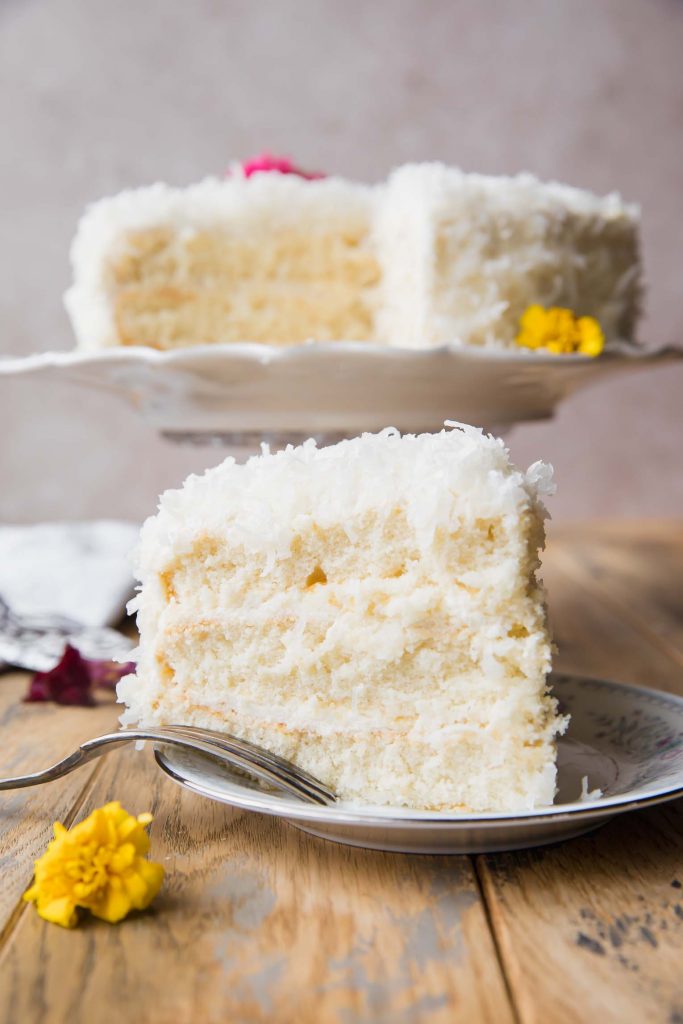 Coconut cake slice with layers and a fork.
