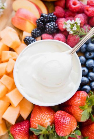 Close up of Cream Cheese Fruit Dip in a bowl with a spoon taking a bite.