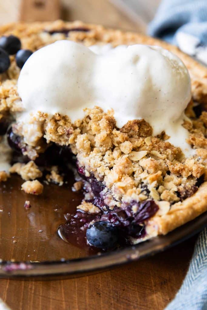 Blueberry Crumble Pie cut out with ice cream on top.