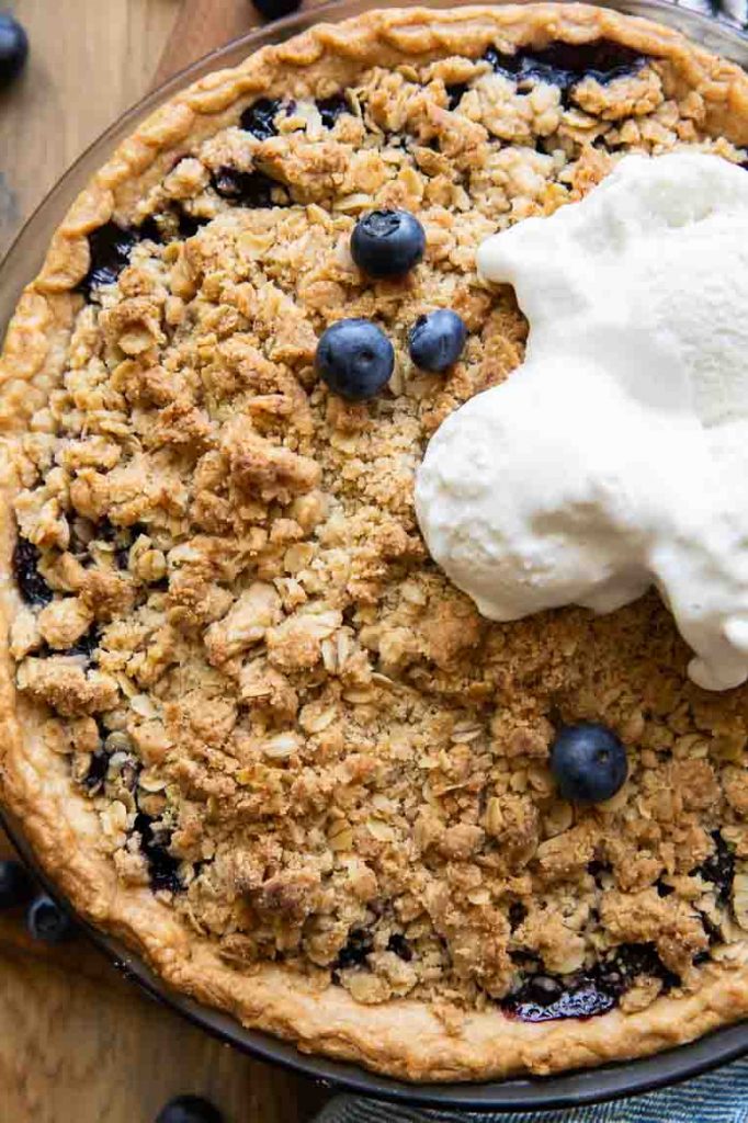 Blueberry crumble pie with ice cream on top.