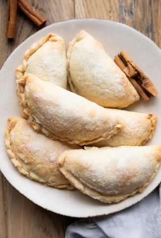 Peach Dessert Empanadas stacked on a plate.